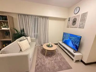a living room with a couch and a flat screen tv at The Camden Place 2BR Haven Cozy Condo Apartment Unit in Manila