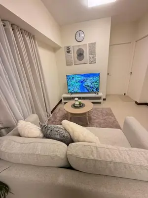 a living room with a couch and a tv at The Camden Place 2BR Haven Cozy Condo Apartment Unit in Manila