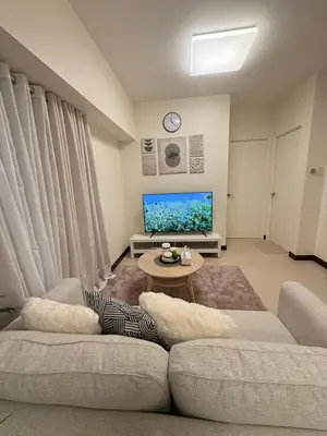 a living room with a couch and a tv at The Camden Place 2BR Haven Cozy Condo Apartment Unit in Manila