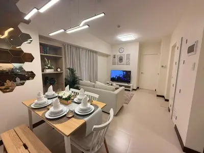 a living room with a dining table and a couch at The Camden Place 2BR Haven Cozy Condo Apartment Unit in Manila