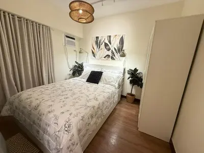 a bedroom with a bed with a black pillow on it at The Camden Place 2BR Haven Cozy Condo Apartment Unit in Manila