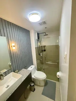 a bathroom with a toilet and a sink and a shower at Nyli Minimalist Suite in Manila