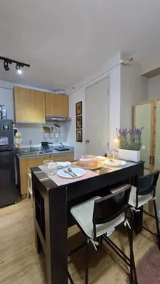 a kitchen with a table and chairs in a room at Metrotowne PHINMA Las Pinas in Manila