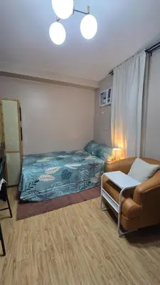 a bedroom with a bed and a couch and a chair at Metrotowne PHINMA Las Pinas in Manila