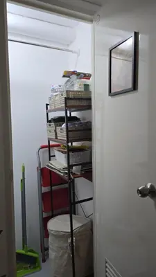 a room with a shelf with books and a door at Metrotowne PHINMA Las Pinas in Manila