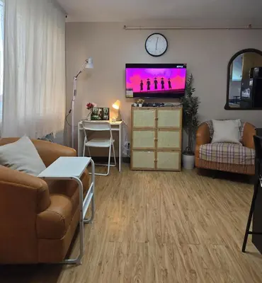 a living room with a couch and a flat screen tv at Metrotowne PHINMA Las Pinas in Manila
