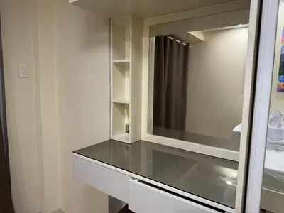 a bathroom with a mirror and a glass counter at PinkdoorZ Moa Staycation at Shell Residences in Manila
