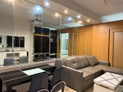 a living room with a couch and a table and chairs at PinkdoorZ Moa Staycation at Shell Residences in Manila