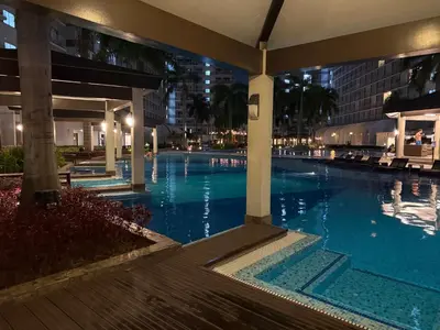 a swimming pool in a hotel at night at PinkdoorZ Moa Staycation at Shell Residences in Manila