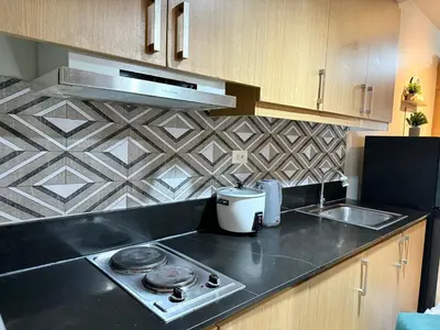 a kitchen with a stove and a counter top at PinkdoorZ Moa Staycation at Shell Residences in Manila