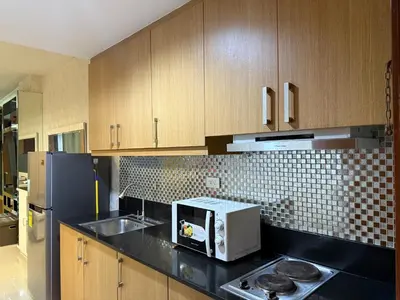 a kitchen with a sink and a microwave in it at PinkdoorZ Moa Staycation at Shell Residences in Manila