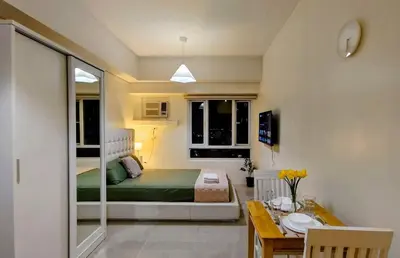 a small room with a bed and a dining table at Bella Suite Netflix Pool Great View in Manila