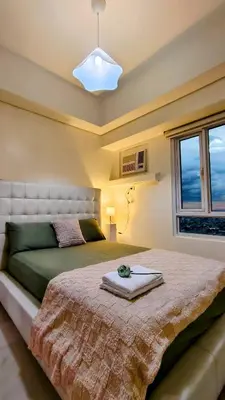 a bedroom with a bed and a window at Bella Suite Netflix Pool Great View in Manila