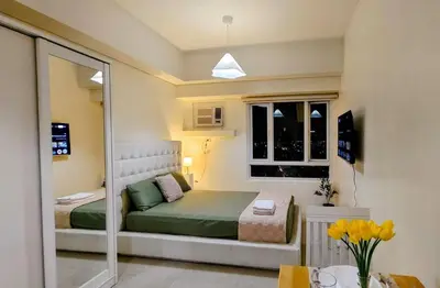 a small bedroom with a bed and a window at Bella Suite Netflix Pool Great View in Manila