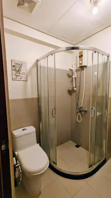 a bathroom with a shower with a toilet and a sink at Bella Suite Netflix Pool Great View in Manila
