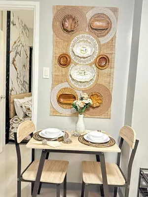 a dining room table with plates and chargers on it at Suite Elegante - Sea Residences Mall of Asia Pasay in Manila