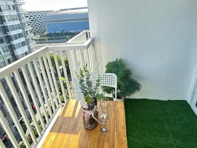 a wooden table with flowers on a balcony at Suite Elegante - Sea Residences Mall of Asia Pasay in Manila