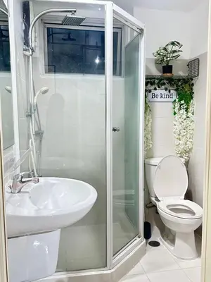 a bathroom with a shower and a toilet and a sink at Suite Elegante - Sea Residences Mall of Asia Pasay in Manila