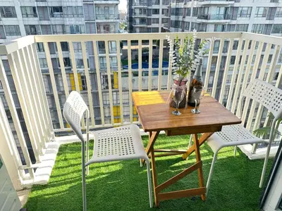 a wooden table on a balcony with chairs and a table at Suite Elegante - Sea Residences Mall of Asia Pasay in Manila