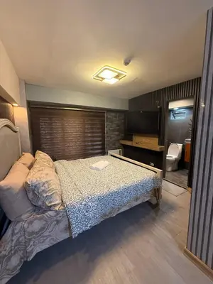 a bedroom with a bed and a bathroom at California Gardens square in Manila
