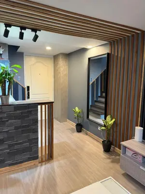 a living room with potted plants and a staircase at California Gardens square in Manila