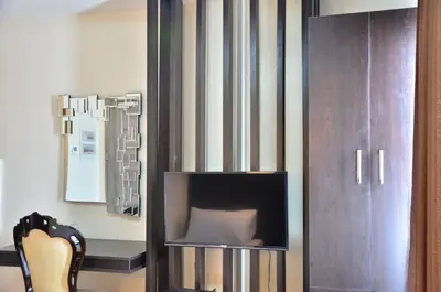 a living room with a tv and a chair at Oriental Zen Suites in Manila