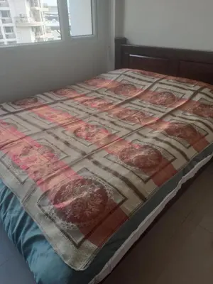 a bed with a quilt on it in a room at Solemare Parksuites in Manila