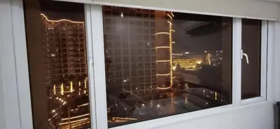 a window with a view of a city at night at Solemare Parksuites in Manila