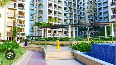 a woman walking down a walkway in front of a building at Solemare Parksuites in Manila