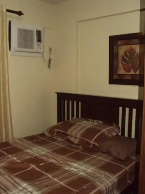 a bedroom with a bed and a air conditioner at Tropical Hawaiian 2BR Condo Unit in Metro Manila with Laundry Area - Sleeps 4 in Manila