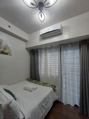 a bedroom with a bed and a ceiling fan at Florian's suite in Air Resideneces Makati in Manila