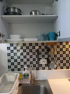 a kitchen with a sink and black and white tiles at Florian's suite in Air Resideneces Makati in Manila