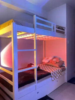 a bedroom with a bunk bed with a ladder at Studio Escapade - Alabang in Manila