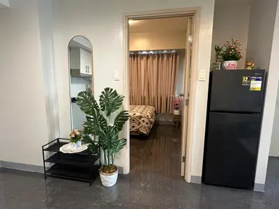 a room with a black refrigerator and a bedroom at Suite Haven - Sea Residences MOA PASAY in Manila