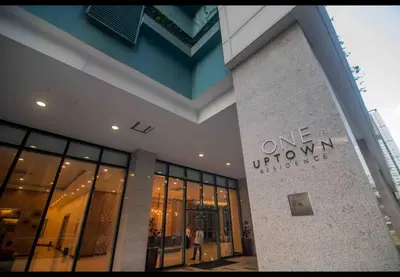 a building with a one woman universe sign on it at One Uptown Residence BGC 1BR sofabed in Manila