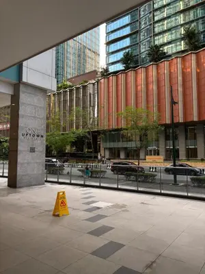 a yellow cone on a sidewalk in front of a building at One Uptown Residence BGC 1BR sofabed in Manila