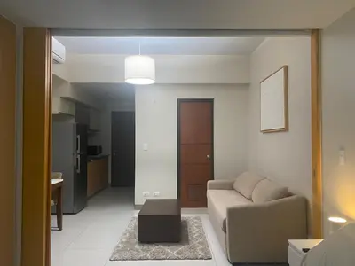 a living room with a couch and a table at One Uptown Residence BGC 1BR sofabed in Manila