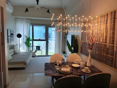 a living room with a dining table and a chandelier at Modern 1BR with Magnificant Garden View, Near Airports, Okada, Solaire with Free Parking in Manila