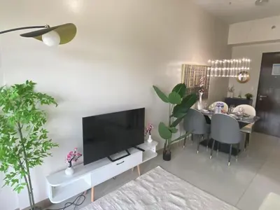 a living room with a television and a dining table at Modern 1BR with Magnificant Garden View, Near Airports, Okada, Solaire with Free Parking in Manila