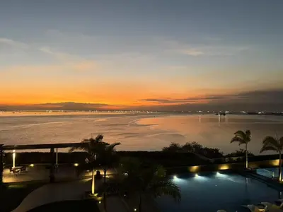 a view of a pool of water at sunset at Playful 1BR With Magnificant Bayview Garden View Near Okada Solaire Aiports with Free Parking in Manila