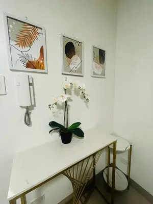 a white table with a plant on it in a room at Shore Residences Moa Pasay in Manila