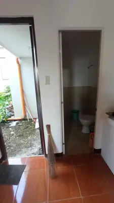 a bathroom with a toilet and a glass door at Amaia Escapes Calamba in Calamba