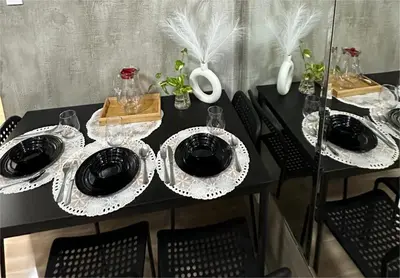 a black table with plates and wine glasses on it at Balai Bacasionan - Sea Residences MOA Pasay in Manila