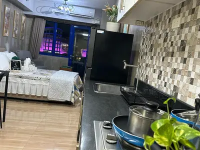 a kitchen with a stove and a bed in a room at Balai Bacasionan - Sea Residences MOA Pasay in Manila