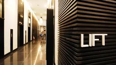 a hallway of a building with the lift sign on the wall at Makati Penthouse Studio with City Views in Manila