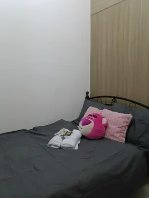 a bed with a teddy bear and towels on it at Shore Staycation with two beds in Manila