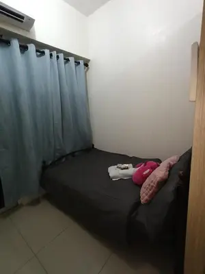 a black bed in a room with a curtain at Shore Staycation with two beds in Manila