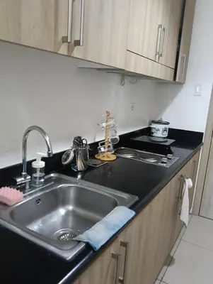 a kitchen with a sink and a counter top at Shore Staycation with two beds in Manila