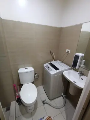 a small bathroom with a toilet and a sink at Shore Staycation with two beds in Manila