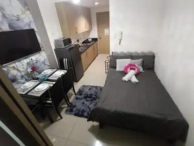 a small room with a bed with a pink stuffed animal on it at Shore Staycation with two beds in Manila